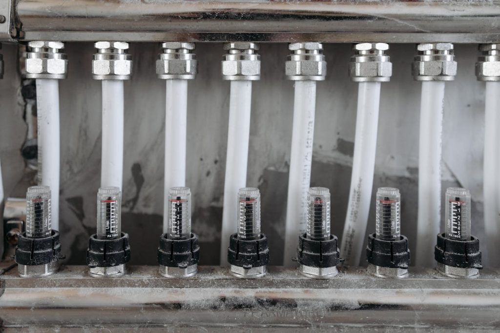 Detailed view of a network of pipes with valves in a metal framework, emphasizing industrial mechanics.